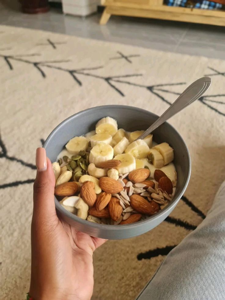 Bowl of oatmeal topped with sliced almonds and banana